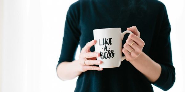 woman holding white mug while standing